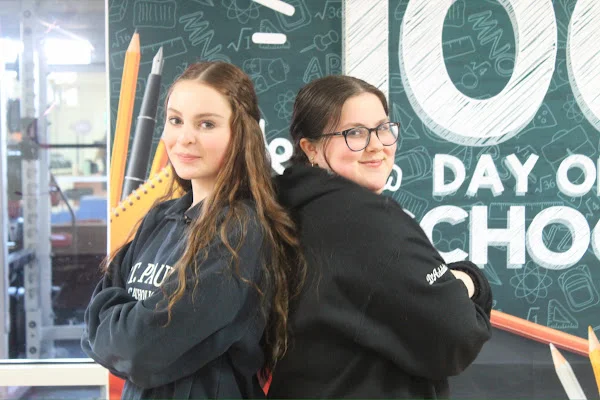 students posing in front of 100th day banner